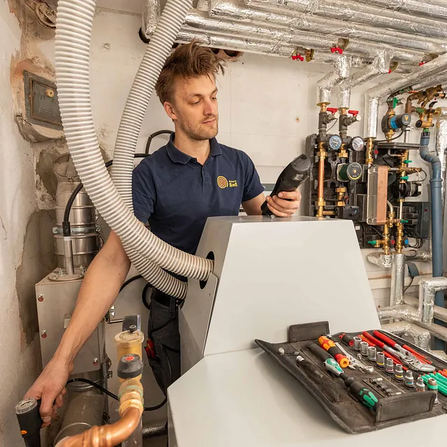 Mitarbeiter arbeitet an Heizungsgerät