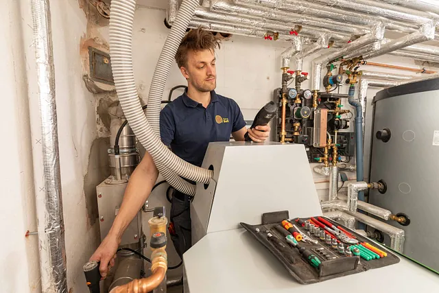 Mitarbeiter arbeitet an Heizungsgerät